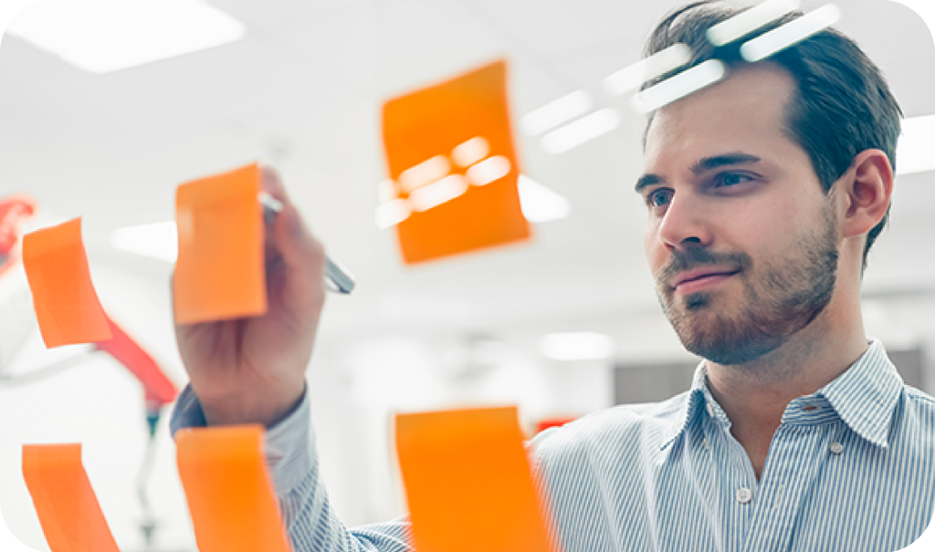 Man Writing On An Orange Sticky Note